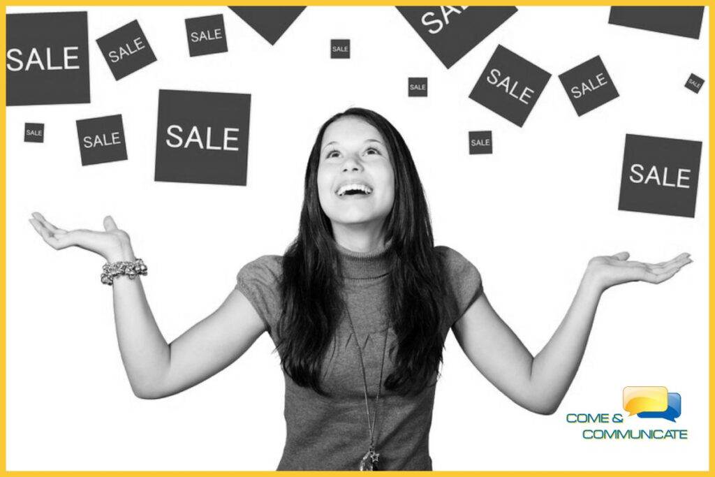 Chica con los brazos abiertos y mirando hacia arriba viendo como llueven cajas con ofertas