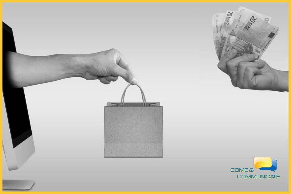 Mano saliendo de un ordenador y entregando una bolsa a una mano que le entrega el dinero por el pedido